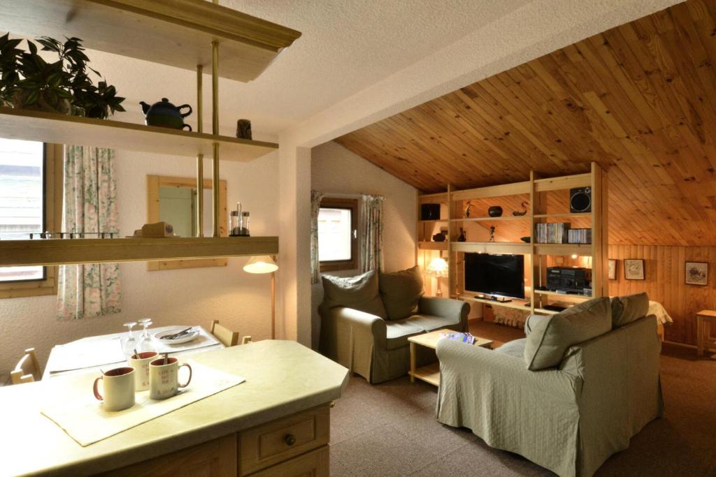 Il dispose d'une cuisine et d'un salon avec un canapé et une chaise. dans l'établissement Résidence Corail - 2 Pièces pour 5 Personnes 74, à Mâcot La Plagne