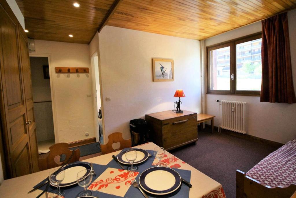 Cette chambre dispose de deux tables, d'un lit et d'une fenêtre. dans l'établissement Résidence Shamrock - charmant, rénové, confortable MAE-3718, à Tignes