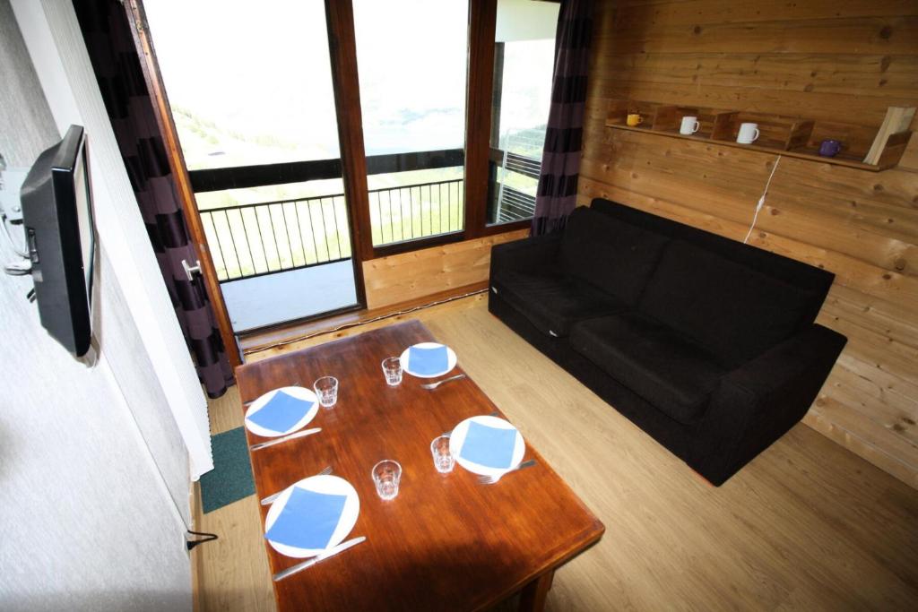 Cette chambre comprend une table avec des verres et un canapé. dans l'établissement Résidence Home Club 1 - studio rénové, chaleureux MAE-3601, à Tignes