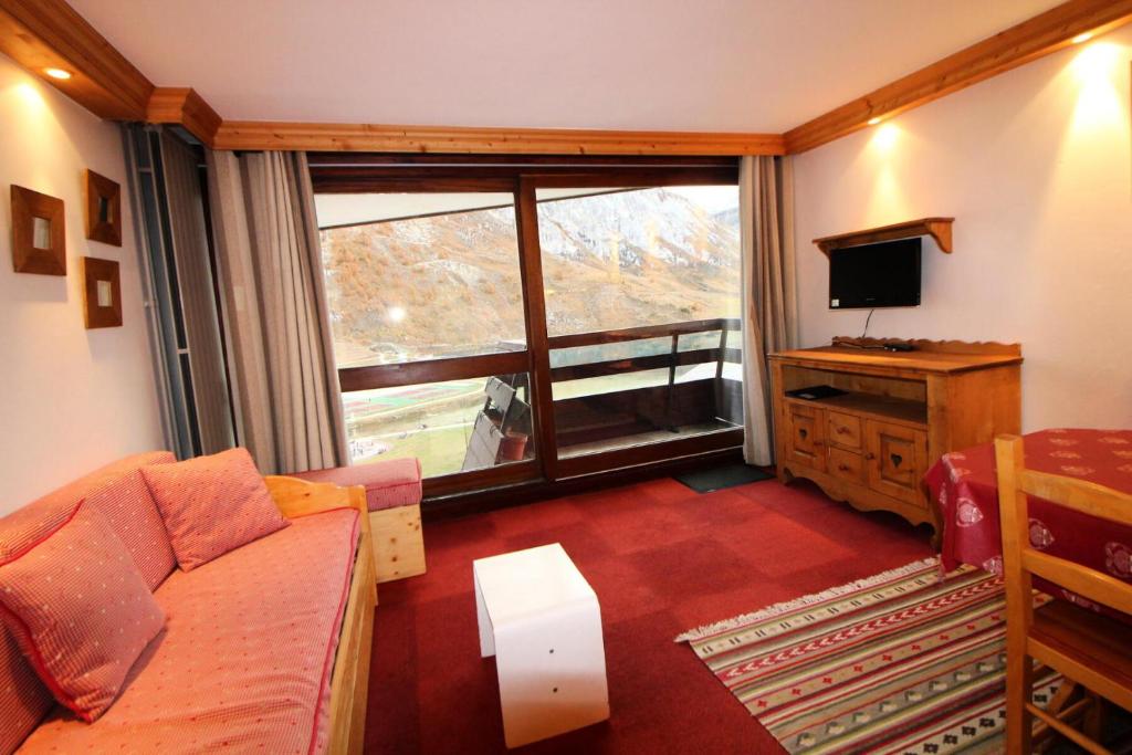 un salon avec un canapé et une grande fenêtre dans l'établissement Résidence Palafour - Grand studio 4 - confortable - balcon - vue lac MAE-3611, à Tignes