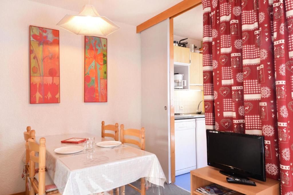une salle à manger avec une table et une télévision dans l'établissement Résidence Les Glaciers 3 - Studio pour 4 Personnes 28, à Mâcot La Plagne