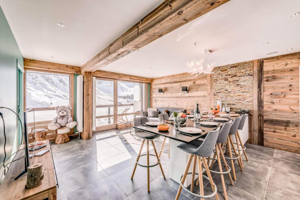 une salle à manger avec une table, des chaises et un ours en peluche dans l'établissement Résidence Shamrock - Appartement 3 magnifiquement rénové - belle vue lac MAE-3758, à Tignes