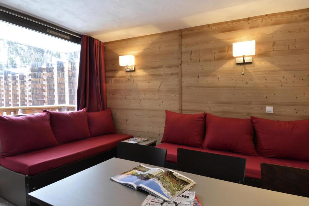 a living room with red couches and a table at Résidence Carroley B - Appartement rénové · Proche des pistes · Vue pistes · Balcon MAE-7112 in Mâcot La Plagne
