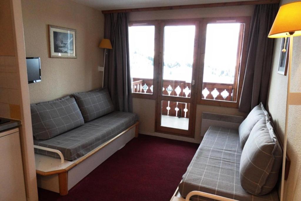 une chambre d'hôtel avec un canapé et une fenêtre dans l'établissement Résidence Themis - 2 Pièces pour 5 Personnes 94, à Mâcot La Plagne