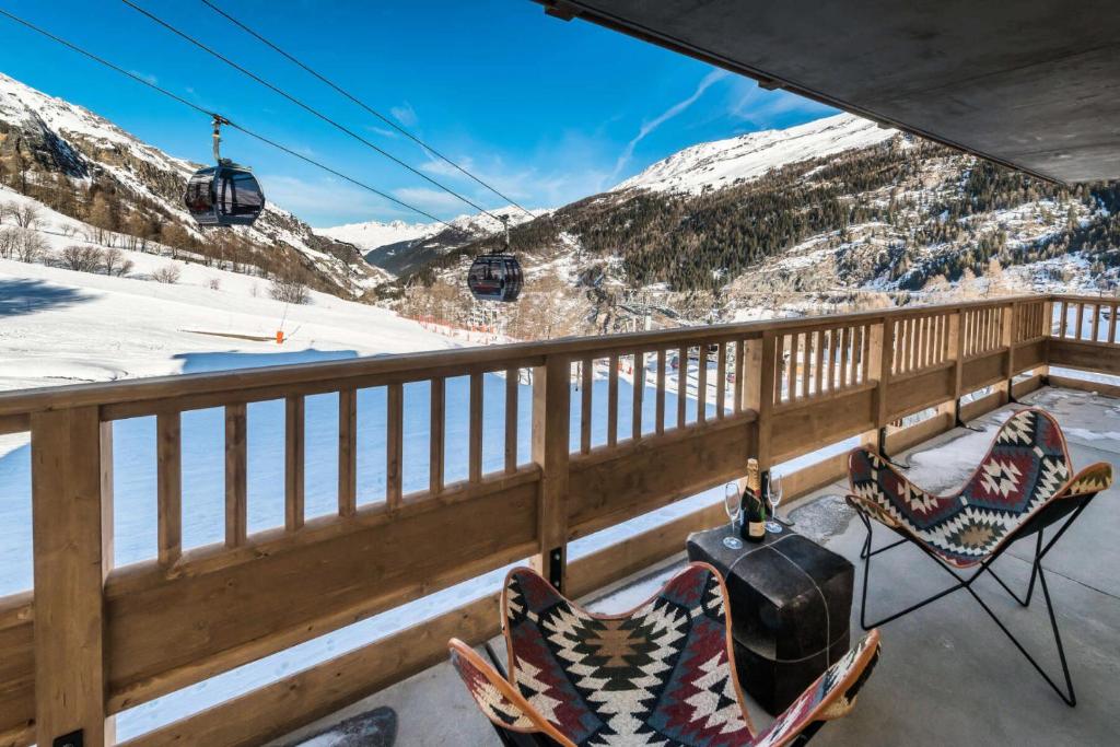 un balcon avec deux chaises et un téléski dans l'établissement Résidence Lodge Des Neiges C - Appartement 4 - pied de pistes, service hotelier inclus MAE-2579, à Tignes