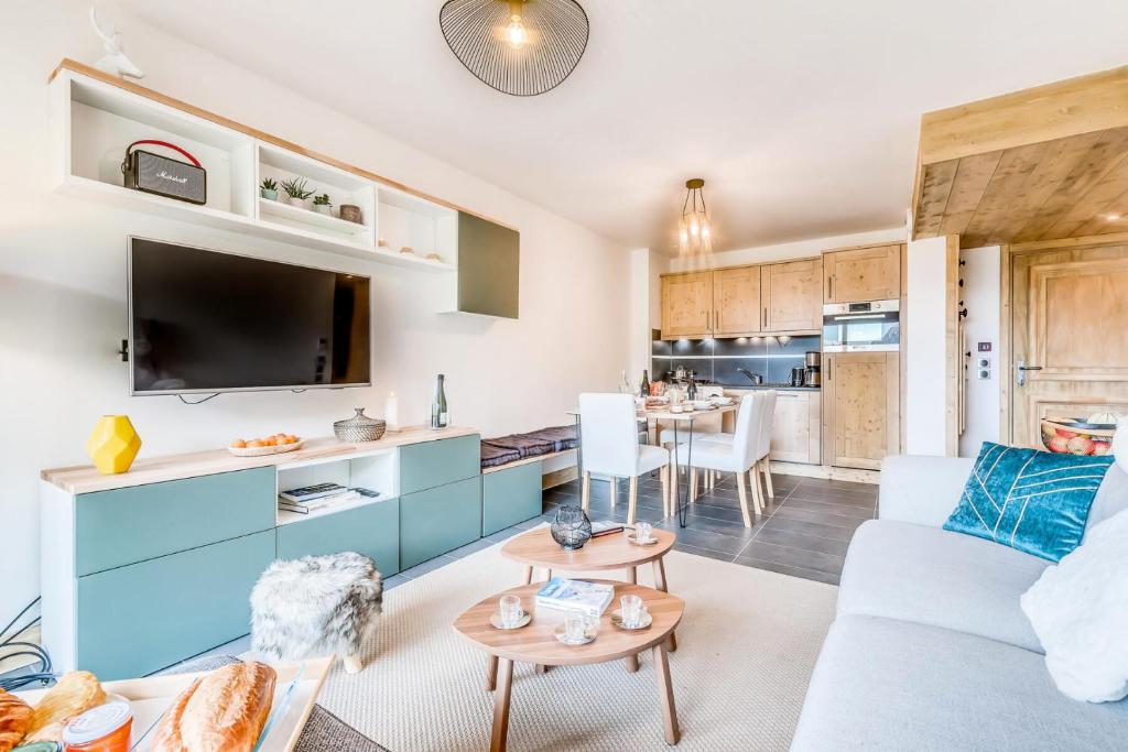 un salon avec un canapé et une cuisine dans l'établissement Résidence Lodge Des Neiges C - Appartement 4 - pied de pistes, service hotelier inclus MAE-2583, à Tignes