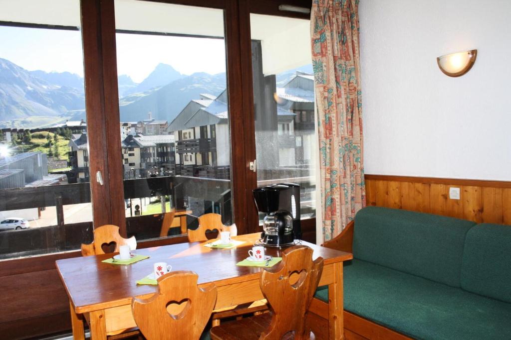 Cette chambre dispose d'une table, d'un canapé et d'une grande fenêtre. dans l'établissement Résidence Home Club 1 - Plusieurs studios disponibles pour vos séjours en famille ou entre amis MAE-3788, à Tignes