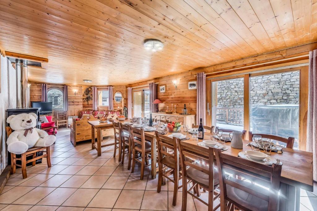 Un comedor con una mesa grande y sillas. en Chalet Gypaete - Chalet Traditionnel 180m2 - 6 chambres, 6 salles de bain, jacuzzi MAE-5886, en Tignes