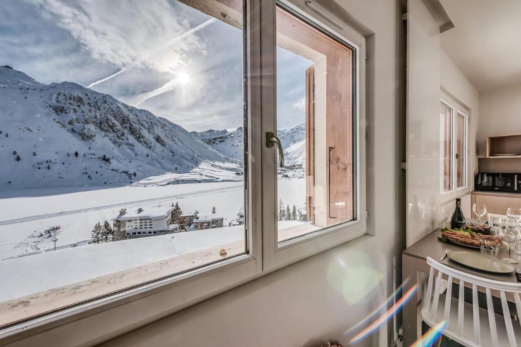 une fenêtre avec vue sur une montagne enneigée dans l'établissement Résidence Armaillis - Appartement rénové, vue lac MAE-6349, à Tignes