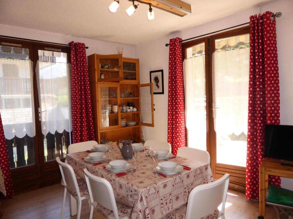 - une table à manger avec des rideaux rouges et blancs dans l'établissement Résidence Aiguille Du Midi Bat A - Aiguille du Midi A778 MAE-6406, aux Houches