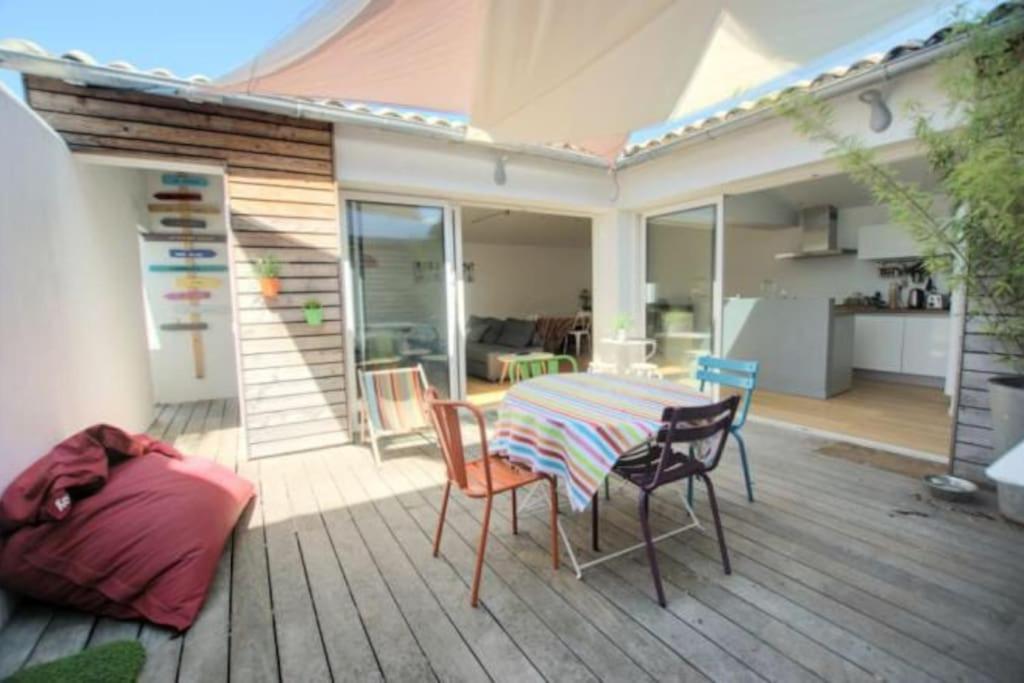 un patio avec une table et des chaises sur une terrasse dans l'établissement Maison récente, à La Flotte