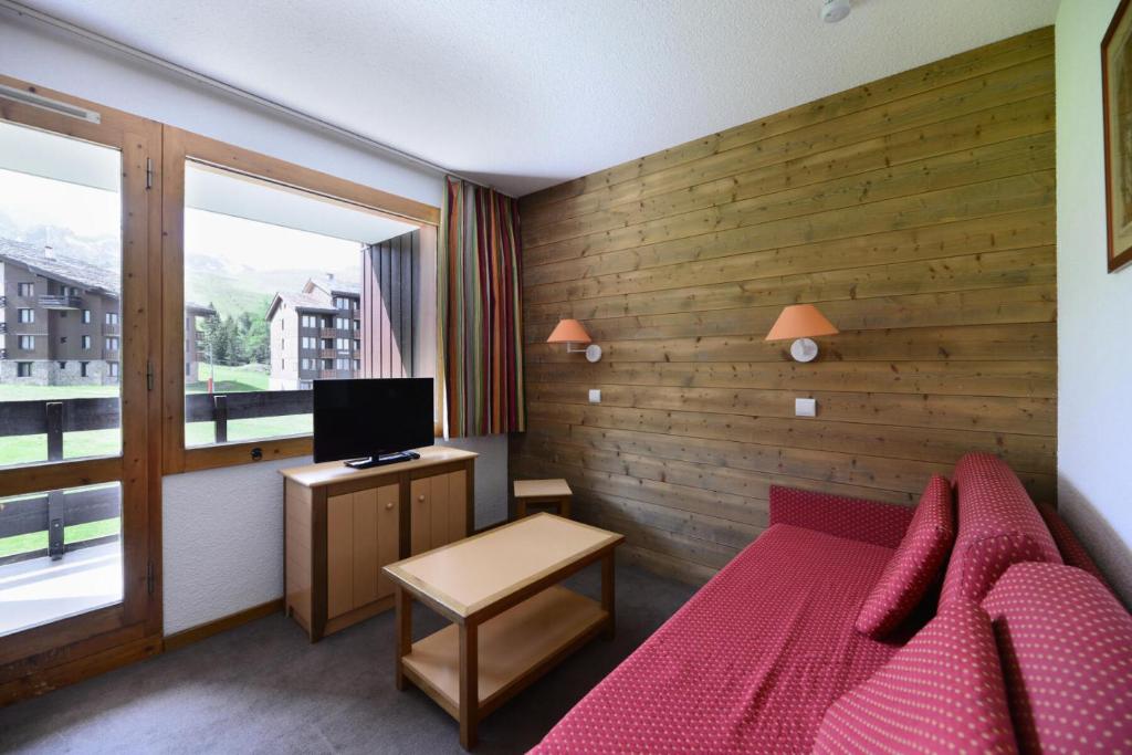- une chambre avec un lit rouge et une télévision dans l'établissement Résidence Agate - Studio pour 4 Personnes 294, à Mâcot La Plagne