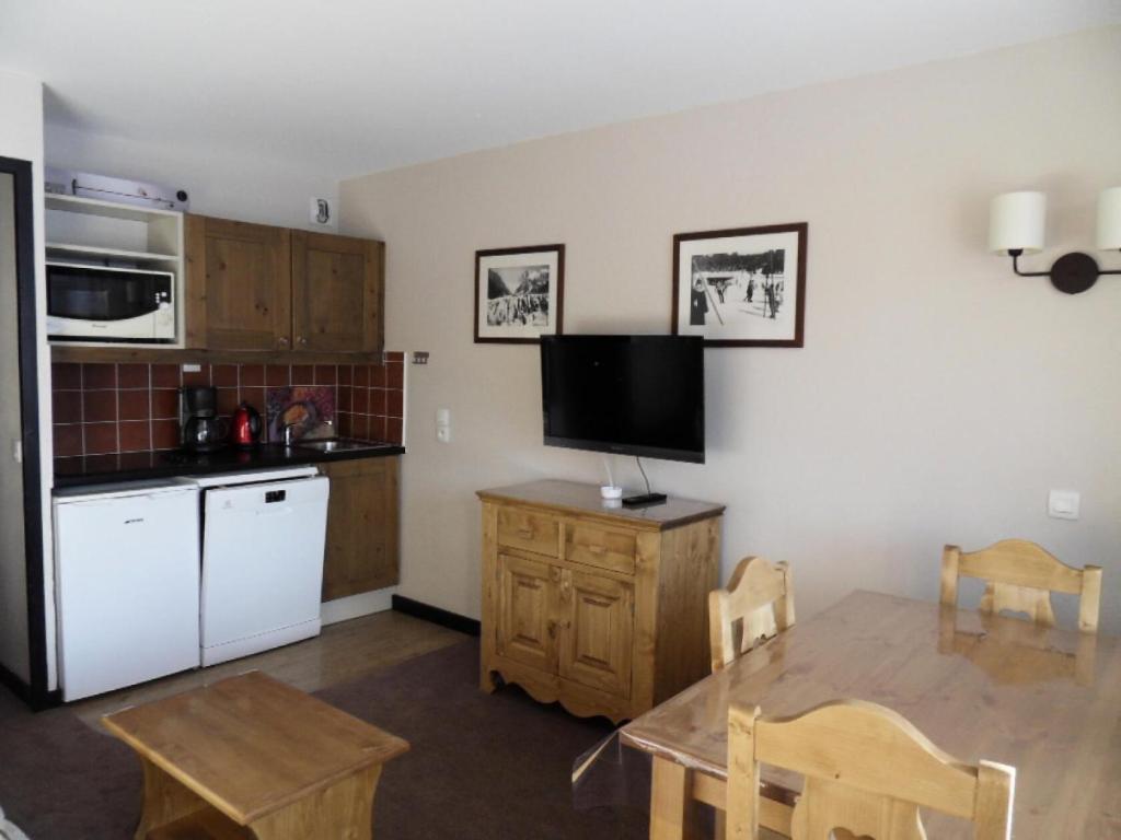 une cuisine avec une table et une télévision murale dans l'établissement Résidence Quartz - 2 Pièces pour 4 Personnes 284, à Mâcot La Plagne