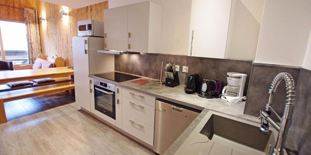 a kitchen with white cabinets and a counter top at Résidence Grand Tichot B - 4 pièces 80m2 - Au coeur du Val Claret MAE-2314 in Tignes