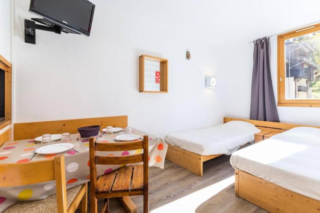 - une chambre avec 2 lits et une table avec une salle à manger dans l'établissement Résidence La Traverse - Studio entièrement rénové MAE-8924, à La Plagne Tarentaise