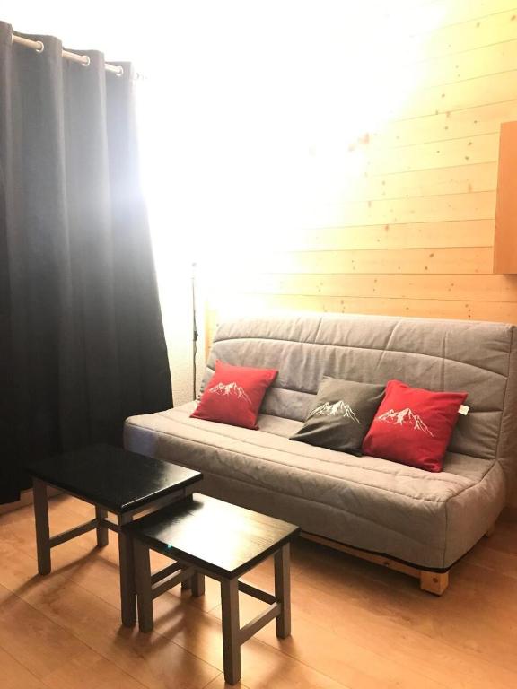 - un canapé avec des oreillers rouges dans le salon dans l'établissement Résidence Le Christiana - Studio sur les pistes MAE-9194, à Aime La Plagne