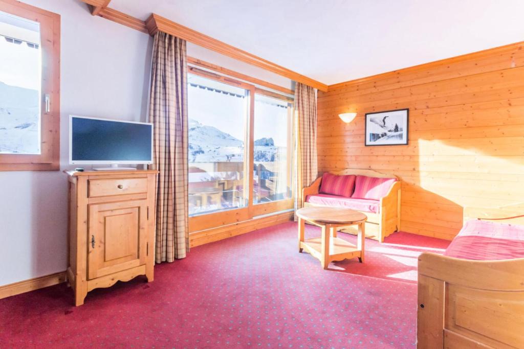 une chambre avec un lit, une télévision et une fenêtre dans l'établissement Résidence Aspen - Appartement avec accès piscine et parking couvert MAE-4524, à La Plagne Tarentaise