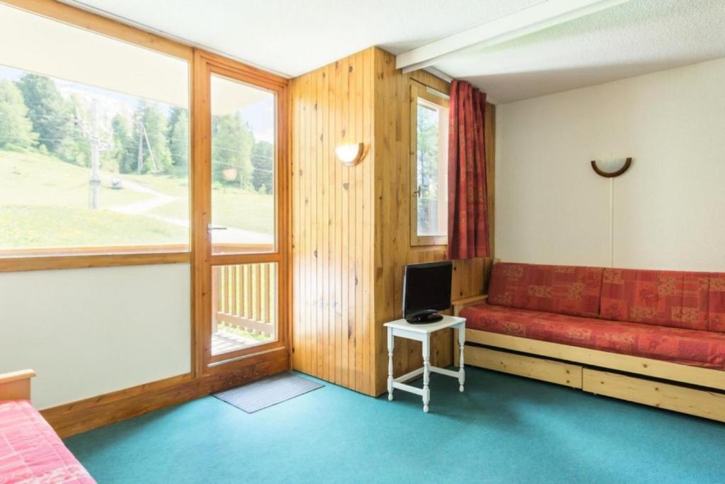 une chambre avec un canapé rouge et une fenêtre dans l'établissement Résidence Soldanelles Villages - Studio divisible 4 personnes - Plagne Village MAE-4824, à La Plagne Tarentaise