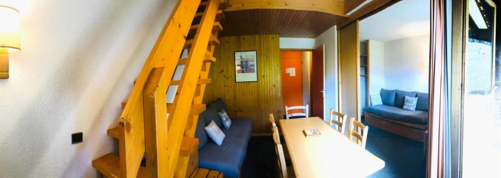 une petite maison avec un escalier en bois et un canapé dans l'établissement Résidence Les Choucas - Appartement duplex sur les pistes MAE-4794, à Aime La Plagne