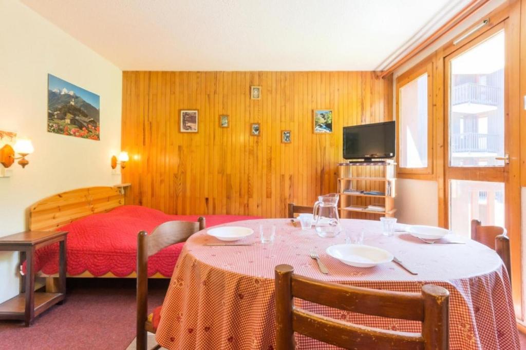 Cette chambre comprend une table, un lit et une télévision. dans l'établissement Résidence La Rochette - Appartement proche du centre de Montchavin MAE-4834, à Aime La Plagne
