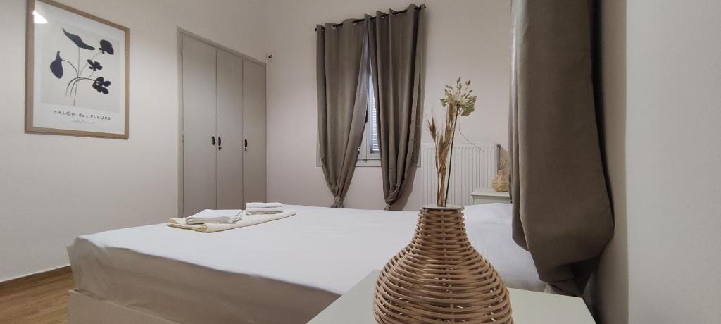 Cette chambre comprend un lit avec un vase sur une table. dans l'établissement Four Reasons, à Sparte