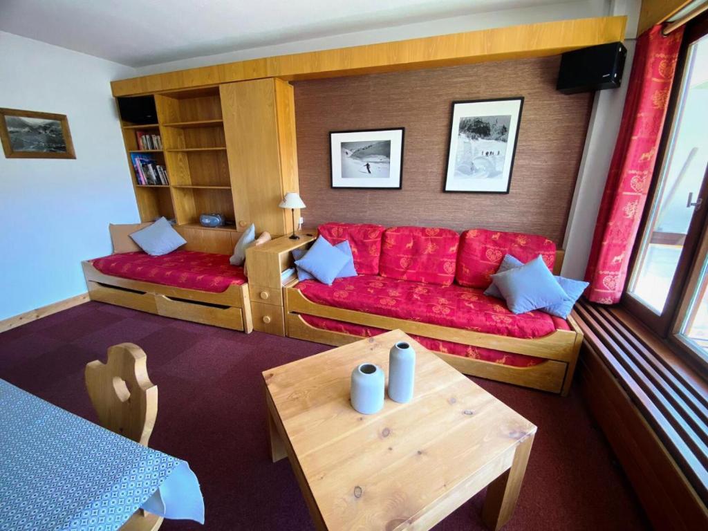 un salon avec un canapé rouge et une table dans l'établissement Résidence Bec Rouge - Appartement lumineux·Accès direct pistes·Balcon MAE-2484, à Tignes