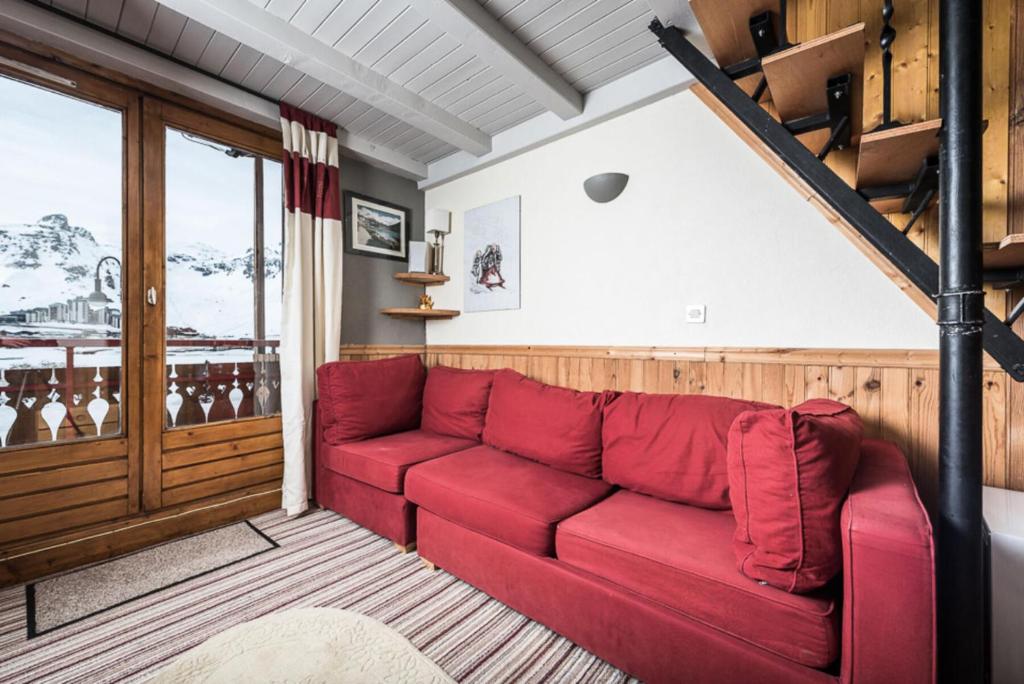 - un canapé rouge dans le salon avec un escalier dans l'établissement Résidence Rosuel - Appartement avec une vue dégagée sur le lac MAE-2544, à Tignes