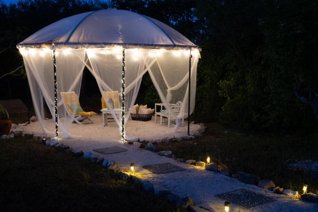 a white tent with chairs and lights in a yard at Casa Vacanze Villa Dan in Impalata