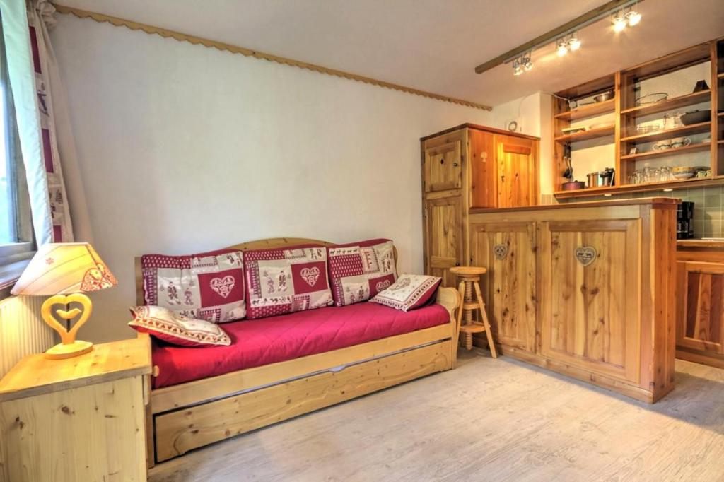 Cette chambre dispose d'un lit avec un canapé rouge. dans l'établissement Résidence Cerro Torre - Studio 2 personnes Plagne Centre MAE-2834, à Aime La Plagne