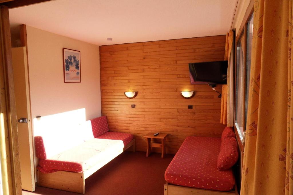 Cette petite chambre dispose d'un canapé et d'une télévision. dans l'établissement Résidence Corail - Studio pour 4 Personnes 044, à Aime La Plagne