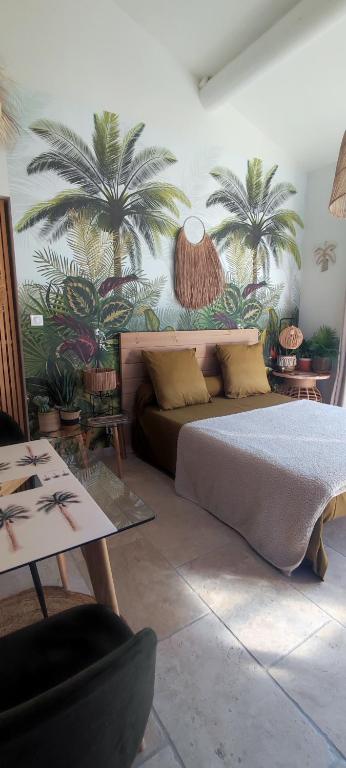 - une chambre avec un lit et des palmiers sur le mur dans l'établissement Chambre d'hôtes Chante Cigale, à La Ciotat