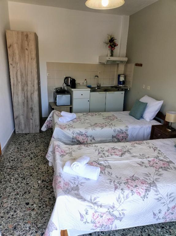 a hotel room with two beds and a kitchen at Sunny Day Studios in Skala Marion