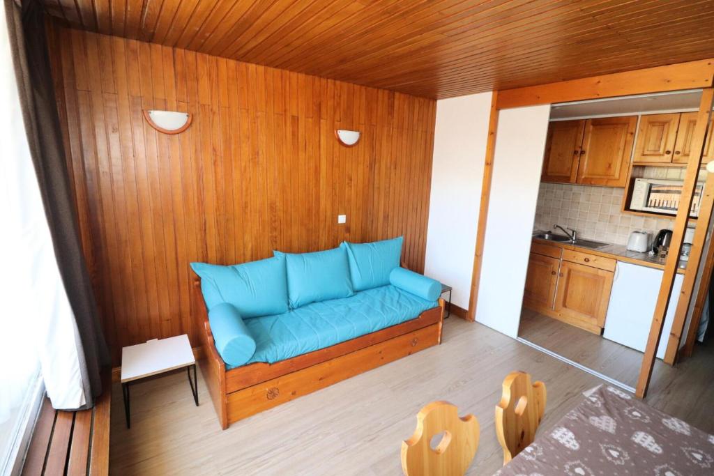 - un canapé bleu dans l'angle de la chambre dans l'établissement Résidence Hauts Lieux - Grand studio ski aux pieds MAE-5004, à Tignes
