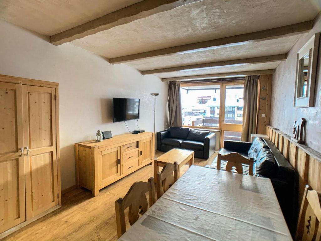 - un salon avec un canapé et une table à manger dans l'établissement Résidence Lot 300 - Appartement spacieux et renové MAE-0524, à Tignes