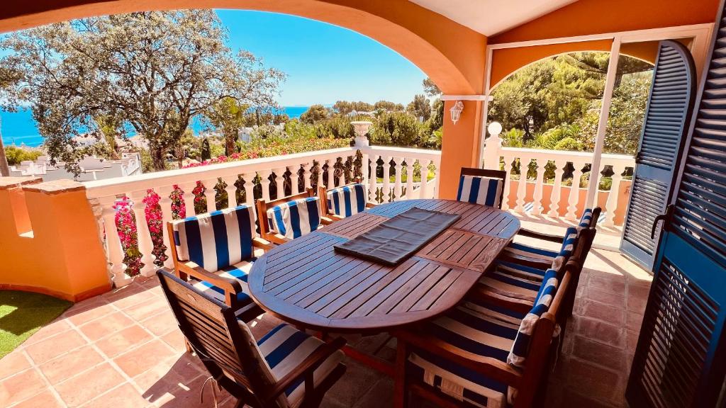 drewniany stół i krzesła na balkonie w obiekcie Casa Alexandra w mieście La Cala de Mijas