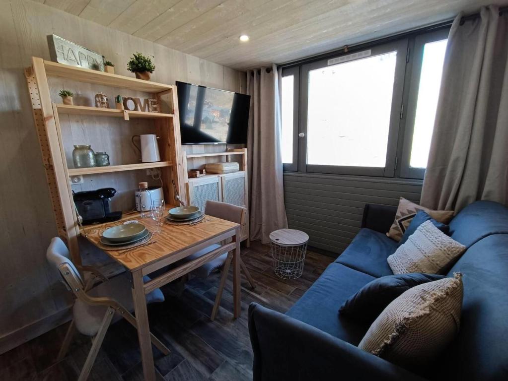 un salon avec un canapé bleu et une table dans l'établissement Résidence Palafour - Studette cosy entièrement rénovée. MAE-3894, à Tignes