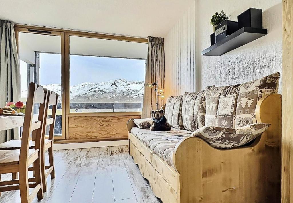 un chien assis sur un canapé dans une pièce avec fenêtre dans l'établissement Résidence Home Club - Bel appartement rénové pouvant acueillir 4 personnes à Tignes Lavachet MAE-2184, à Tignes