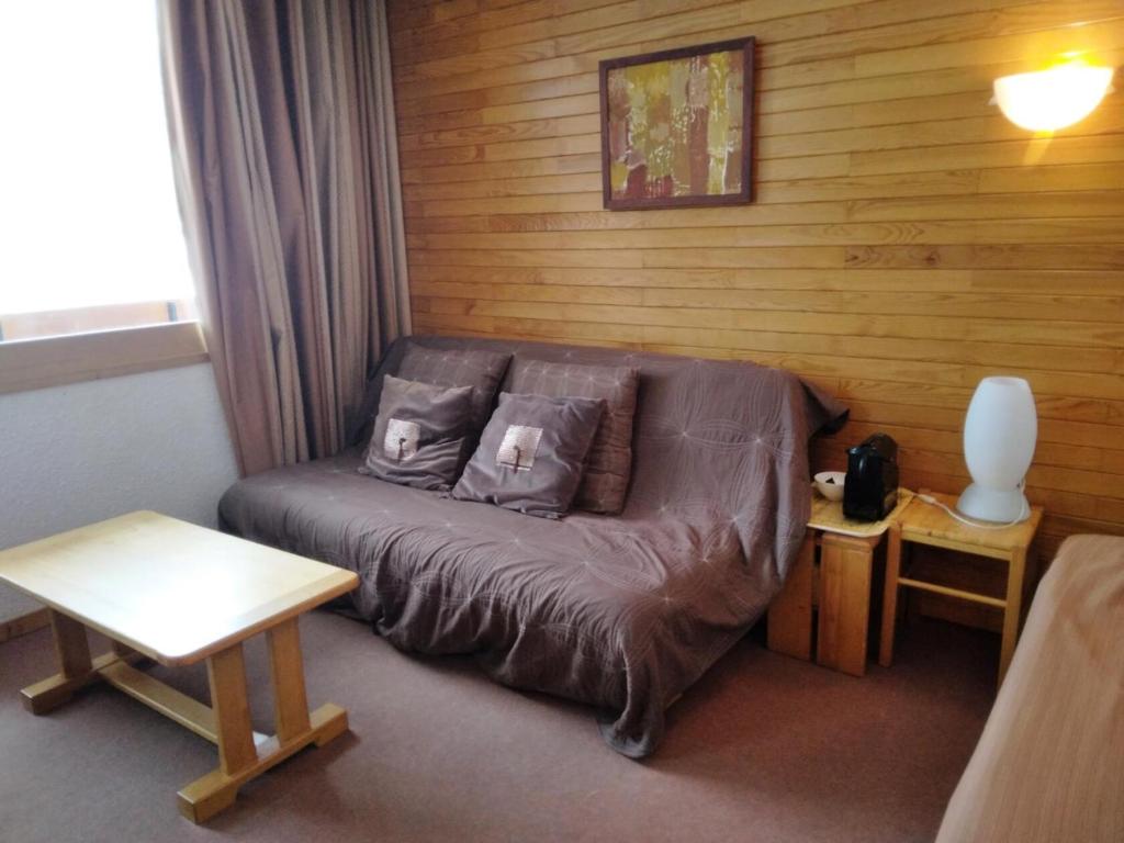 - un canapé dans une chambre dotée d'un mur en bois dans l'établissement Résidence Les Glaciers 3 - 2 Pièces pour 5 Personnes 214, à Aime La Plagne