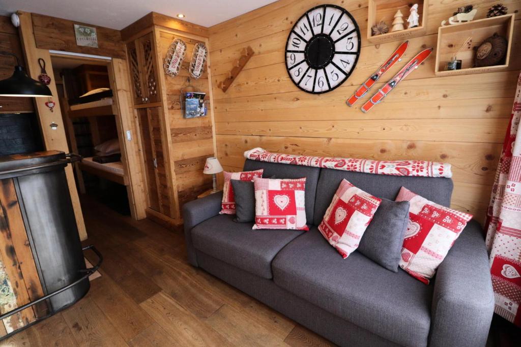un salon avec un canapé et une horloge au mur dans l'établissement Résidence Home Club - Studio rénové · proche piste et commerce · balcon MAE-9081, à Tignes