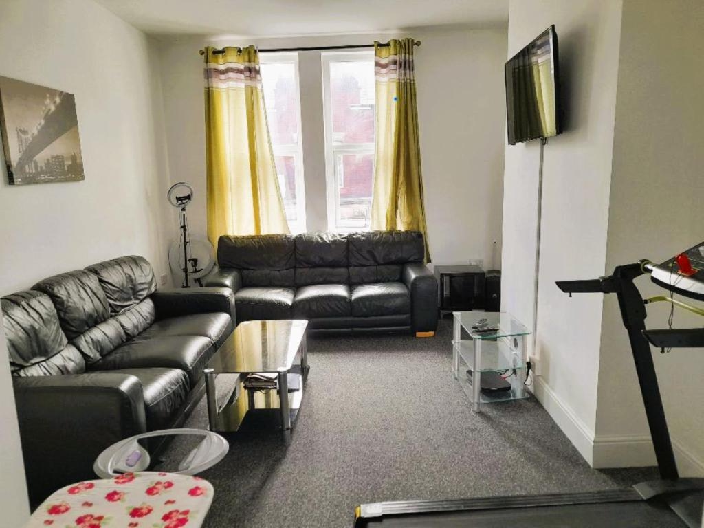 a living room with a leather couch and a table at ACCANE in Sunderland