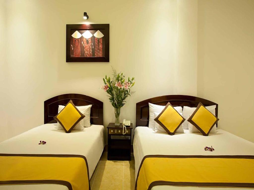 Postel nebo postele na pokoji v ubytování Hoi An Hai Au Boutique Hotel