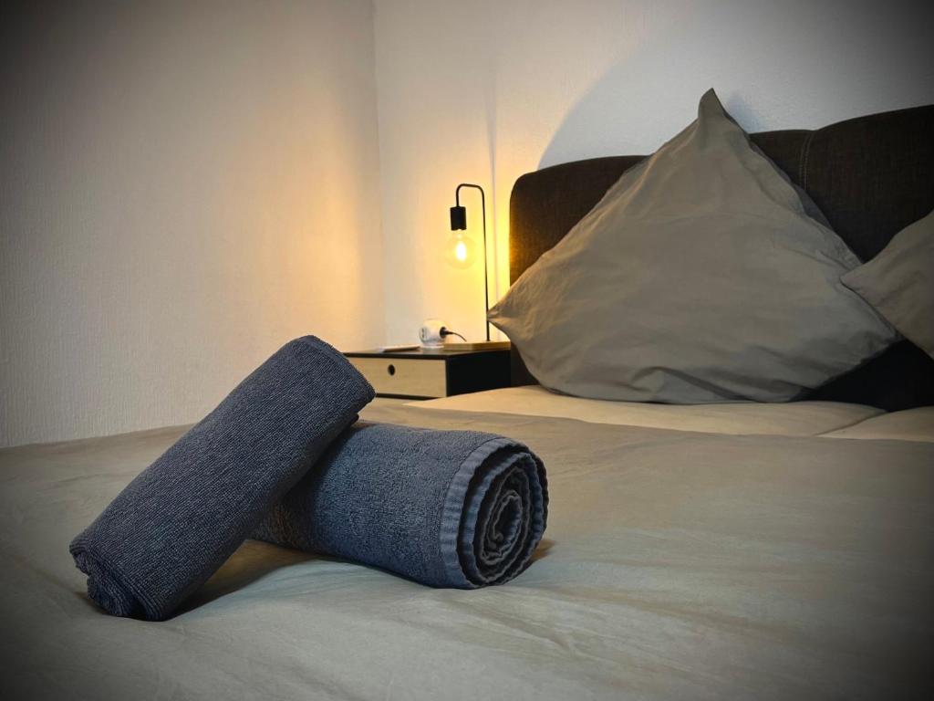 a rolled up blue towel sitting on a bed at G&G Homely Apartment Horhausen Westerwald - near A3 in Horhausen