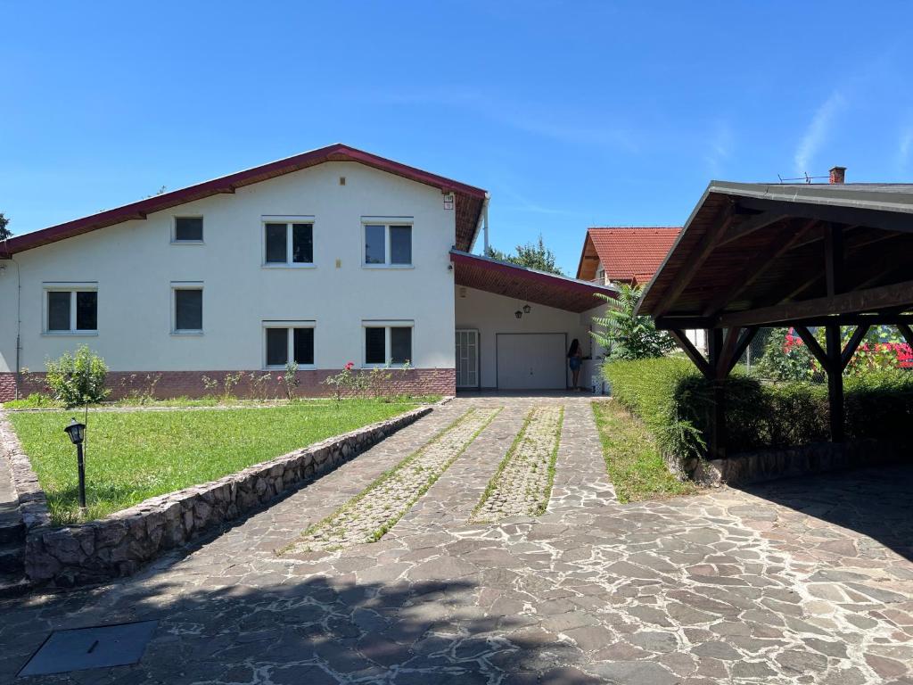 a stone driveway leading to a white house at -Self-Check- 4-Room Extra large house in Nitra