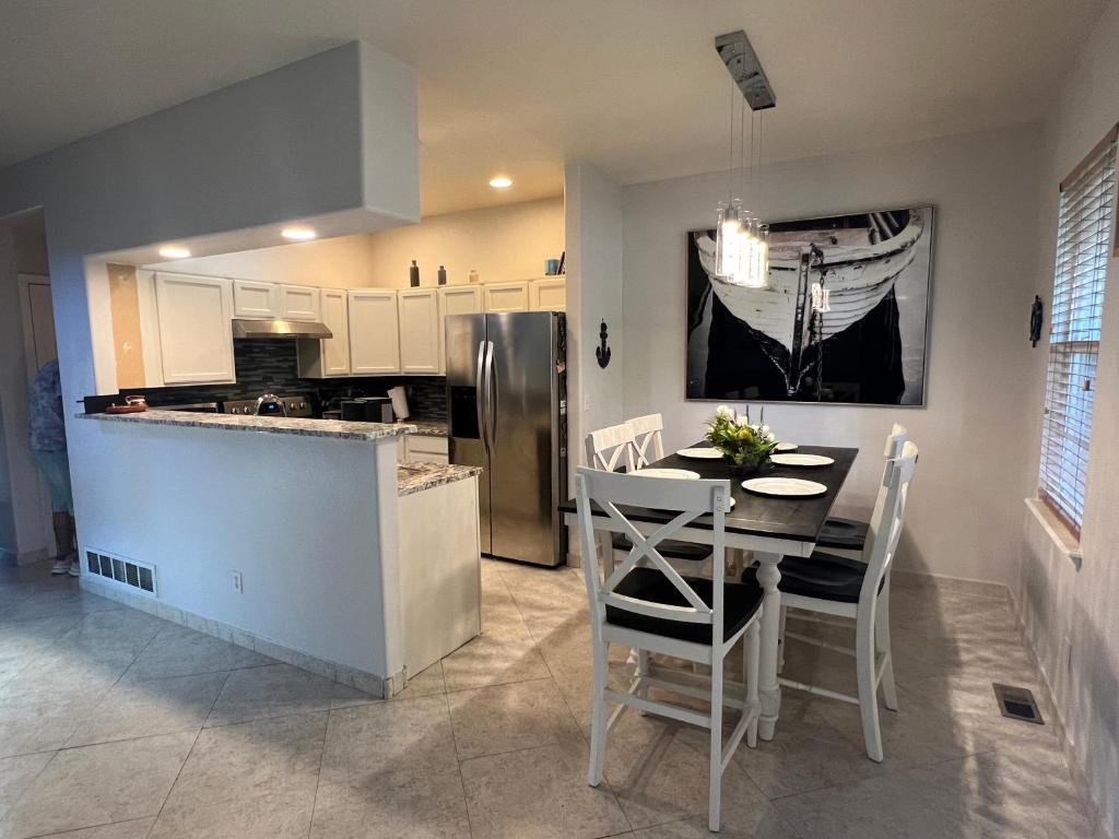 een keuken en eetkamer met een tafel en een koelkast bij InHomeStays in Lakewood