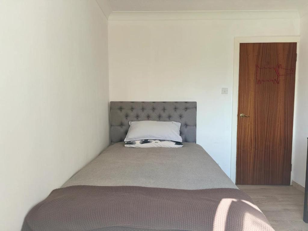 a bed in a white room with a pillow on it at Double Room with Deluxe Bathroom in Southbourne