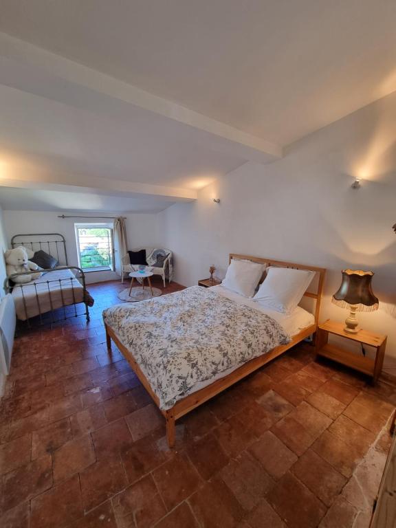 une chambre avec un grand lit dans une pièce dans l'établissement Belle chambre dans maison de charme, à Caunes-Minervois
