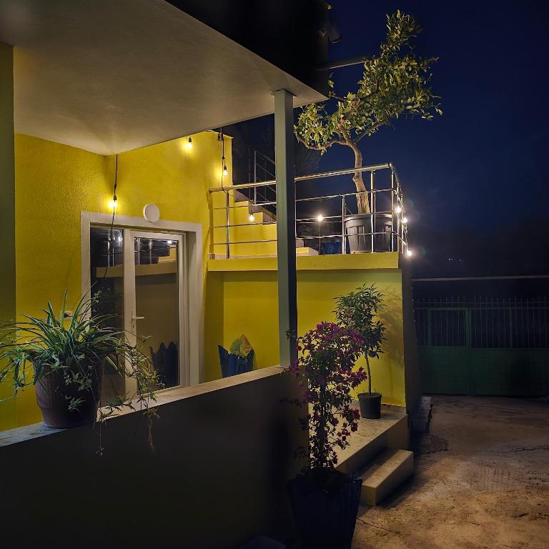 a yellow house with plants on the side of it at night at Lemon House Borsh in Himare