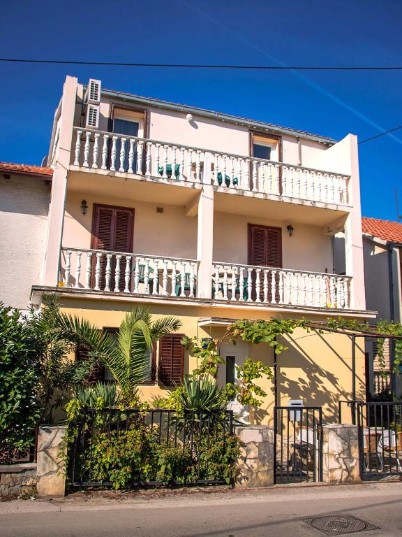 a white building with a balcony on top of it at Apartments Anna in Zadar