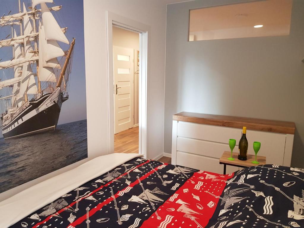 a bedroom with a bed with a pirate ship on the wall at Morski Apartament 50 m od plaży ApartPark in Świnoujście