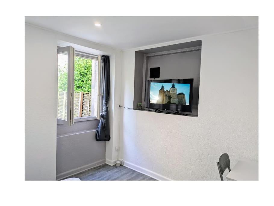 un salon avec une télévision sur un mur dans l'établissement Studio de Tokyo, à Montbéliard